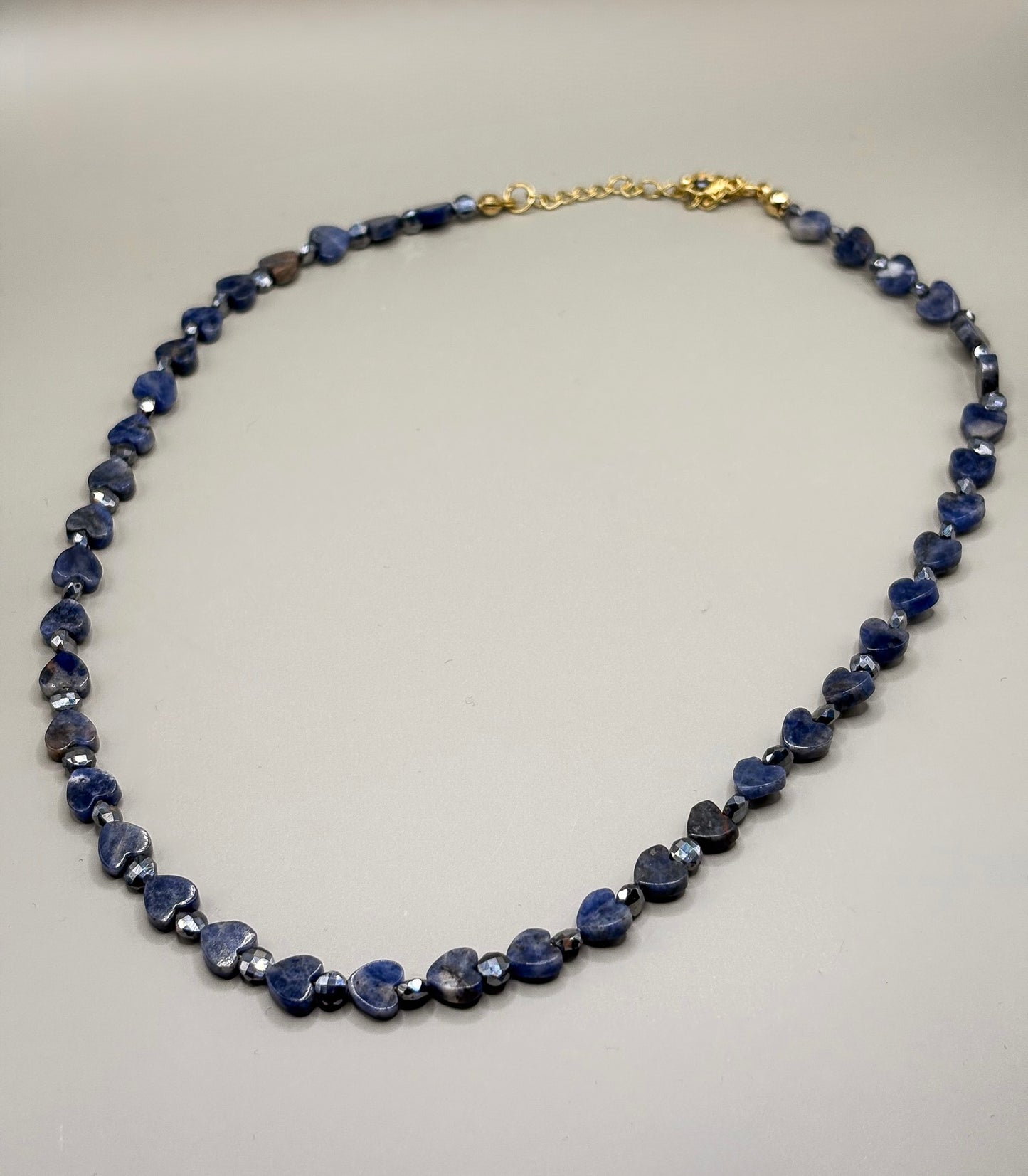 „Naszyjnik Blue Intuition z serduszek sodalitu – biżuteria premium”
„Delikatny naszyjnik z serduszkami z naturalnego sodalitu”
„Zbliżenie niebieskich serduszek sodalitu w naszyjniku Blue Intuition”