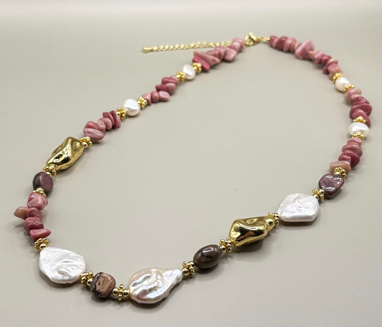 Naszyjnik Rose Harmony z rodonitu i pereł naturalnych – biżuteria premium”
„Różowy naszyjnik z rodonitu i pereł na złotych akcentach”
„Zbliżenie naszyjnika z rodonitu i pereł – kolekcja High Vibes”