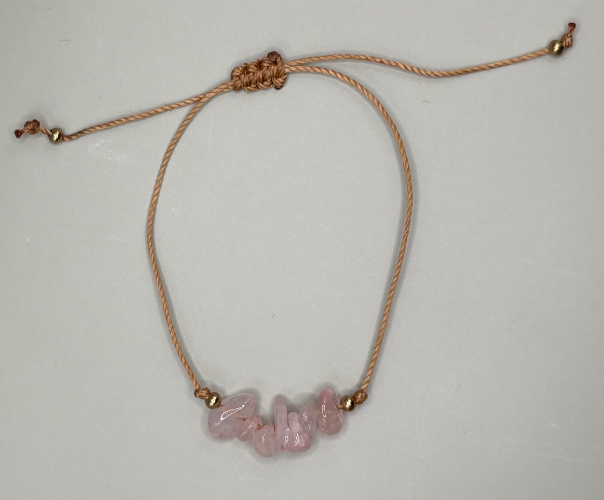 „Regulowana bransoletka na sznurku z naturalnym kwarcem różowym – kolekcja BASIC.”