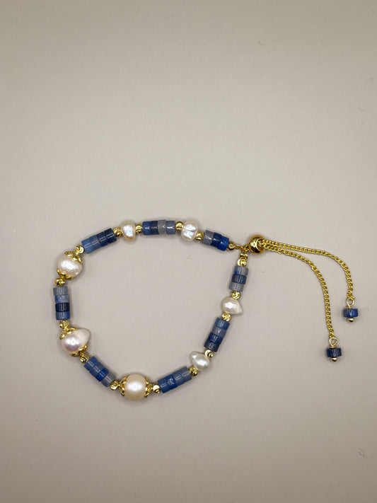 Bransoletka Blue Aura z kianitu i pereł słodkowodnych, wykończona złotymi elementami”

„Delikatna bransoletka z naturalnego kianitu i pereł – biżuteria premium błękitna”

„Zbliżenie bransoletki z kianitu i pereł, z regulowanym złotym zapięciem”