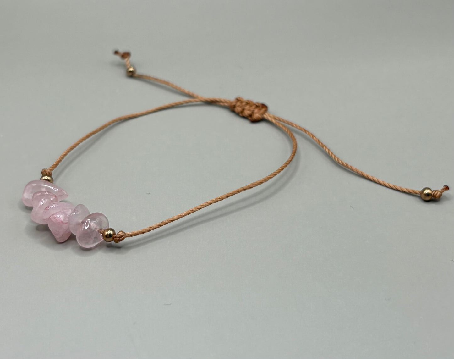 „Regulowana bransoletka na sznurku z naturalnym kwarcem różowym – kolekcja BASIC.”